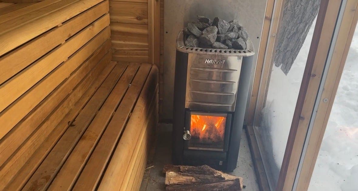 A Harvia wood-burning heater stacked with stones inside a cedar-lined sauna